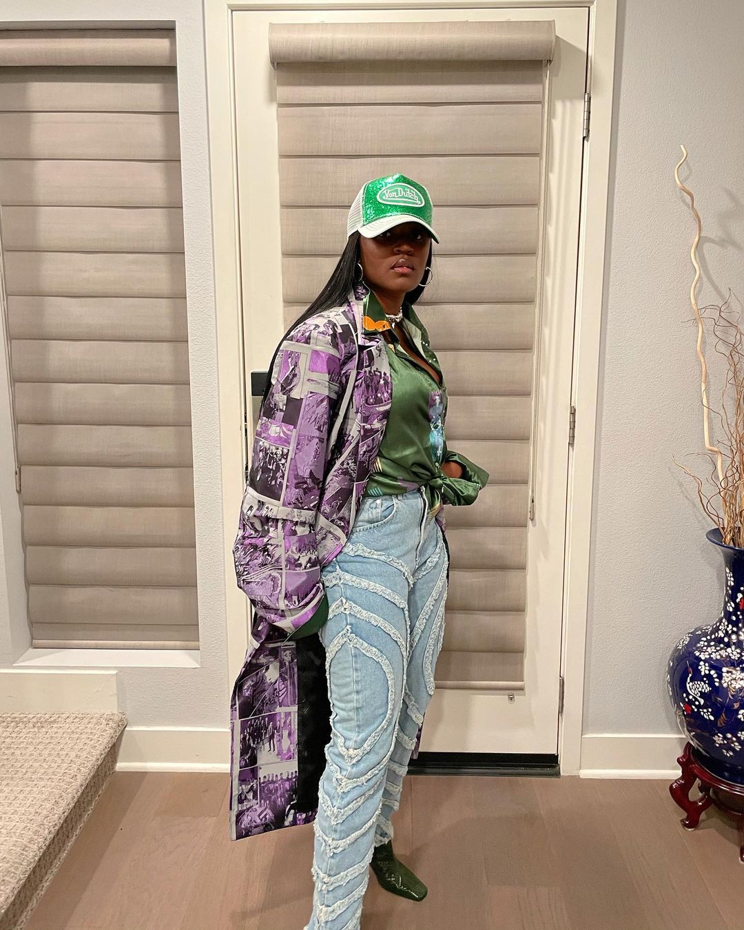 Amaarae in jeans, green shirt, green shoes and a purple coat featured as a fashionable African female artiste